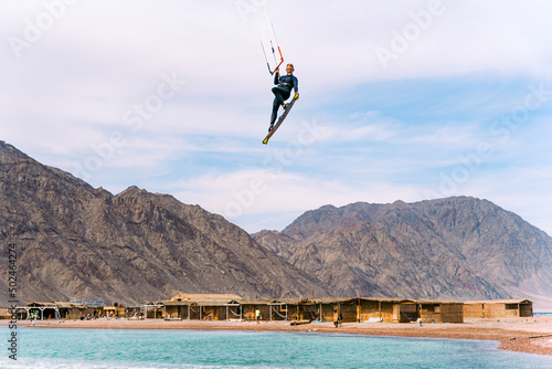 Kiteboarder jumping high near Bedouins village in Blue Lagoon, Sinai, Egypt photo