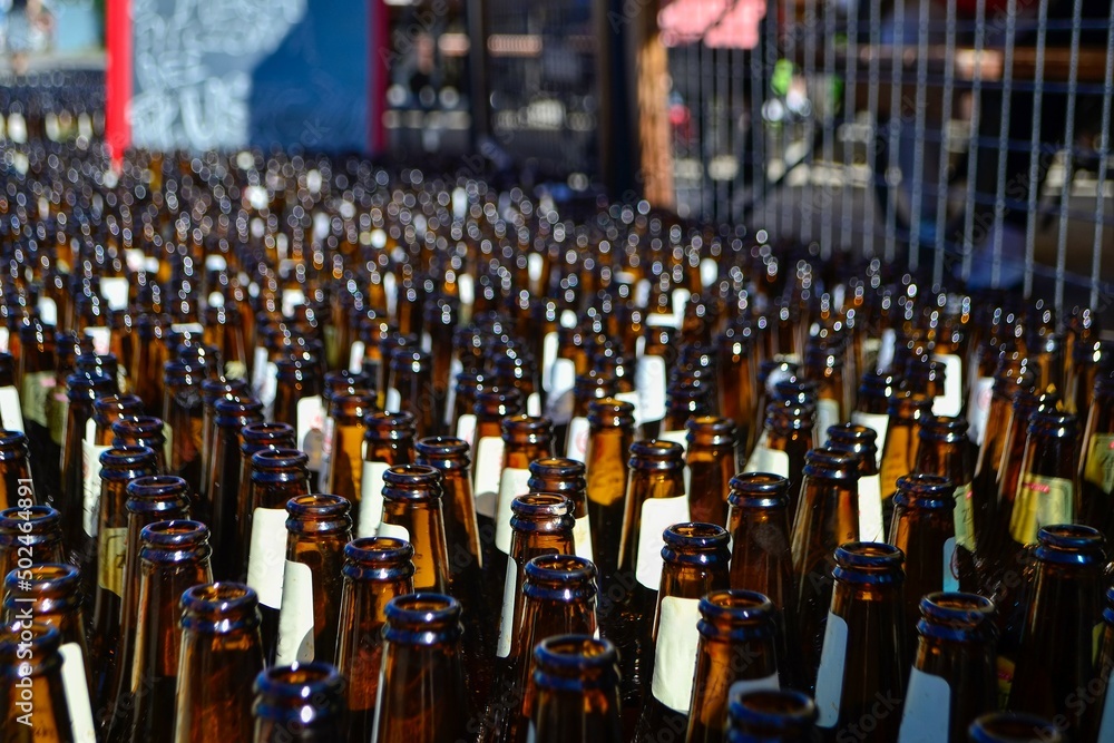 Lots of empty glass beer bottles stacked on the street, Leba, Poland