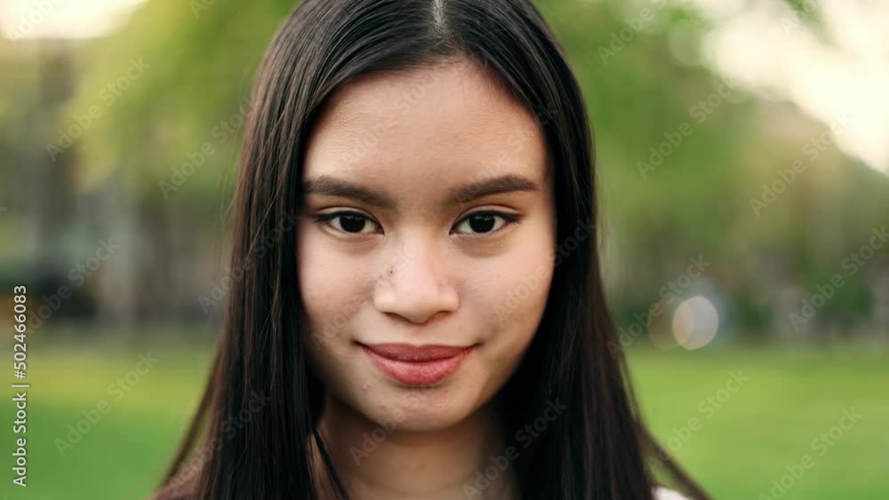 Portrait of a gorgeous dark haired woman smiling while sitting in the city street. Beautiful woman looking at camera outside. Portrait of a gorgeous dark haired woman smiling while sitting in the city street. Beautiful woman looking at camera outside.