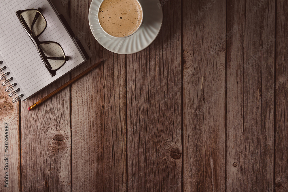 Workspace with notebook, glasses and coffee on wooden background. Top view. Copy space. Selective focus. Workspace with notebook, glasses and coffee on wooden background. Top view. Copy space. Selective focus.