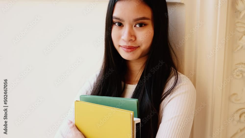 Portrait of student asian girl with books near the university building. Happy and smiling young woman. Portrait of student asian girl with books near the university building. Happy and smiling young woman.