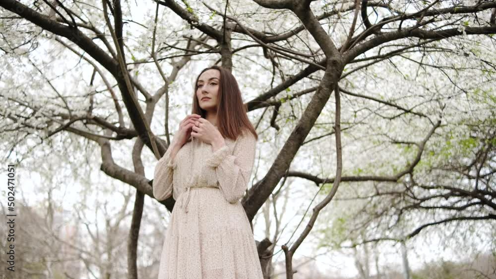 Portrait of young beautiful ukrainian brunette woman in the flowered garden in the spring time Portrait of young beautiful ukrainian brunette woman in the flowered garden in the spring time
