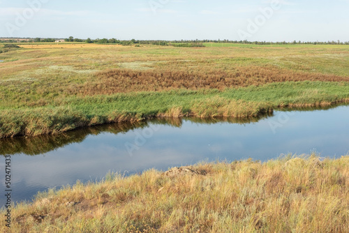 rural landscape of a field with a river on the background of a cloudy sky august ukraine