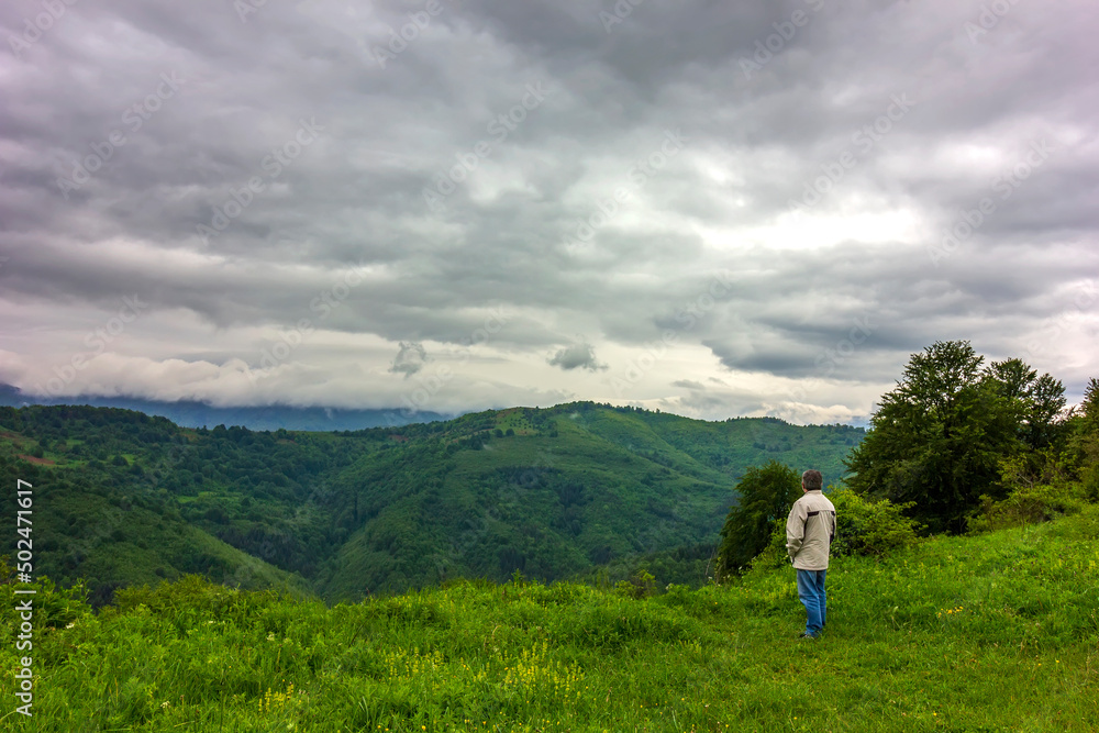 Fototapeta premium A man enjoys a beautiful view from top .Travel in the mountains.