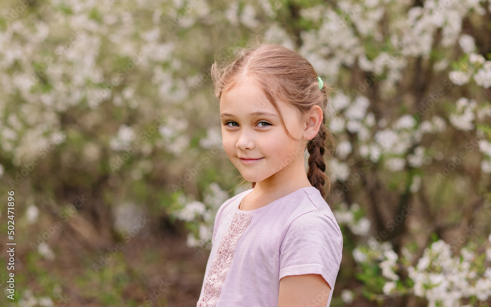 Adorable little girl in blooming cherry garden on beautiful spring day Adorable little girl in blooming cherry garden on beautiful spring day