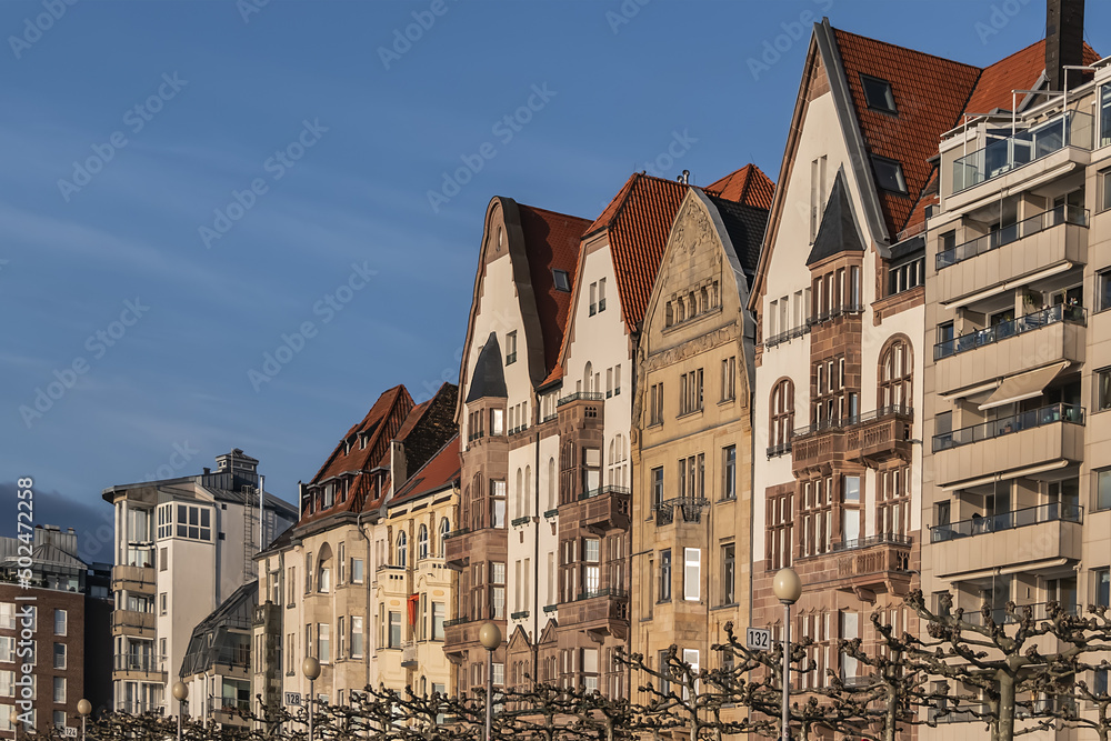 Beautiful traditional medieval buildings along the picturesque river Rhine promenade at sunset. DUSSELDORF, GERMANY.