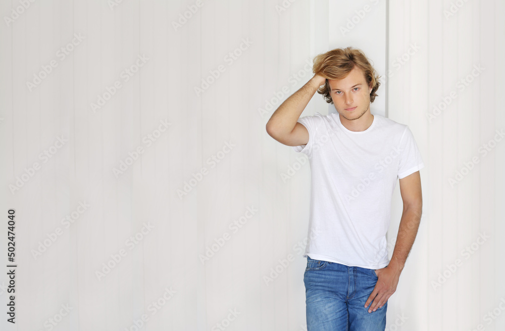 Teenager standing near white wall. Teenager standing near white wall.