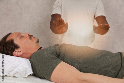 Man having energy healing treatment , alternative medicine, holistic care concept. photo