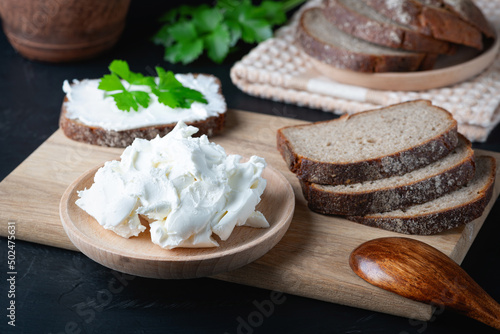 Home made bread on a wooden cutting board with curd cheese and ricotta photo