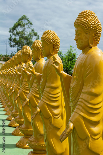 yellow buddha statues gesturing with hands and fingers in the buddhist temple Chen Tien or "templo budista" in portuguese, in the city of foz do iguaçu in brazil