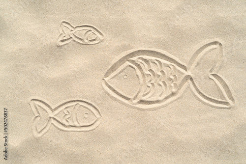 Silhouettes of a fishes painted on the sand