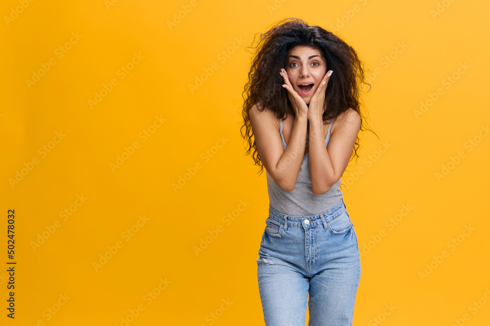 COOL OFFER. Excited pretty Latin female with afro with open mouth recline on hands, smile at camera, say wow, stay isolated over yellow background. Copy space, free place COOL OFFER. Excited pretty Latin female with afro with open mouth recline on hands, smile at camera, say wow, stay isolated over yellow background. Copy space, free place