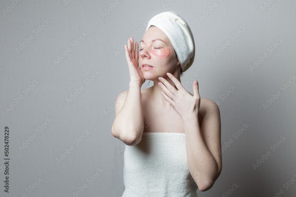 beautiful woman eye patches. A woman makes procedures in a spa salon. Towel on the head. The body is wrapped in a towel. beautiful woman eye patches. A woman makes procedures in a spa salon. Towel on the head. The body is wrapped in a towel.