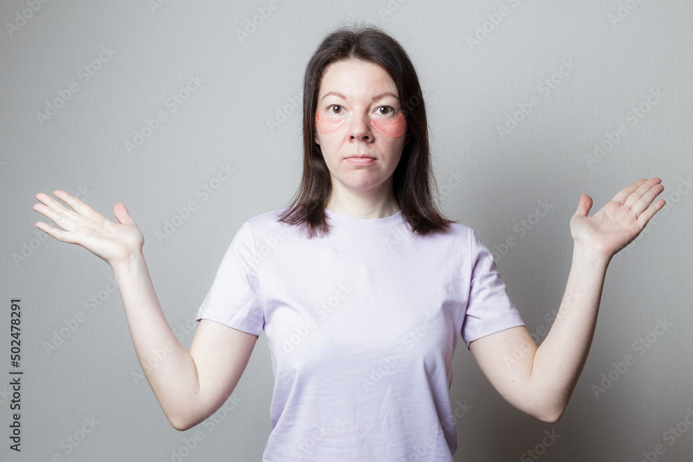 beautiful girl makes a cosmetic procedure. The girl uses eye patches. Skin care under the eyes. woman throws up her hands. beautiful girl makes a cosmetic procedure. The girl uses eye patches. Skin care under the eyes. woman throws up her hands.