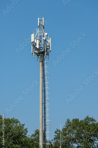 Ecology and technology concept of ecology conservation on planet earth. 5G communication tower for Internet and mobile communications against background of blue sky and green foliage.