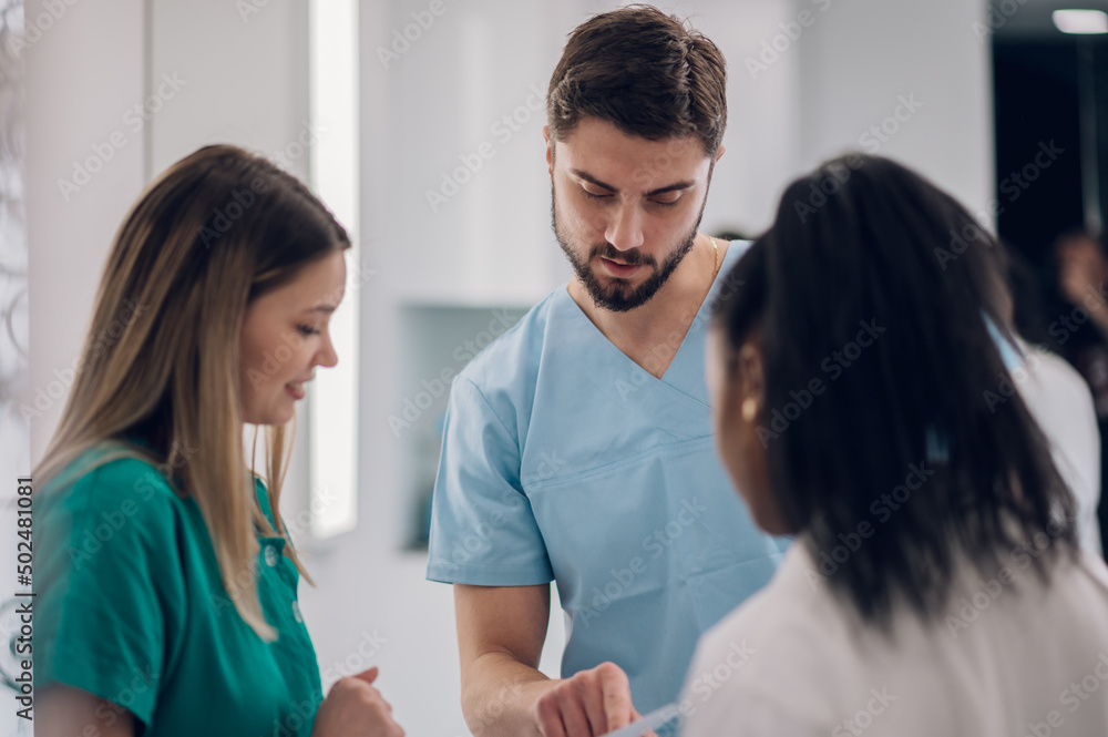 Multiracial team of doctors discussing a patients condition while working in a hospital Multiracial team of doctors discussing a patients condition while working in a hospital