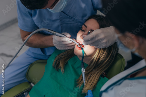 Woman patient in dental clinic being examined by a male dentist