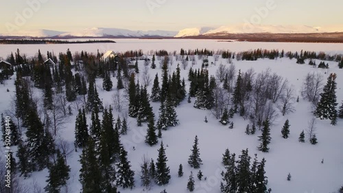 Aerial shooting. view of the plane window. Beautiful winter landscape. Village with wooden houses. Dense coniferous forest. Heavy snowfall in Siberia.