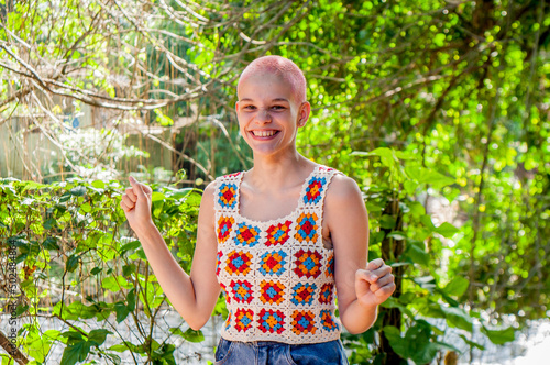 Portrait of a girl with very short hair, dyed pink. Portrait of girl wearing crochet outfit. Portrait of girl with short hair. Portrait of young girl outdoors. Portrait of girl smiling.