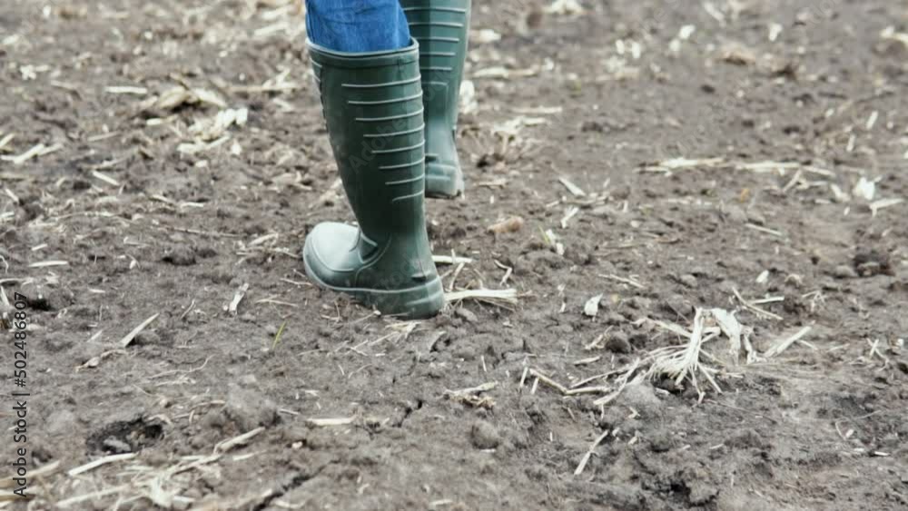 Farmer worker goes home after harvesting end of the working day feet in rubber boots agriculture Farmer worker goes home after harvesting end of the working day feet in rubber boots agriculture