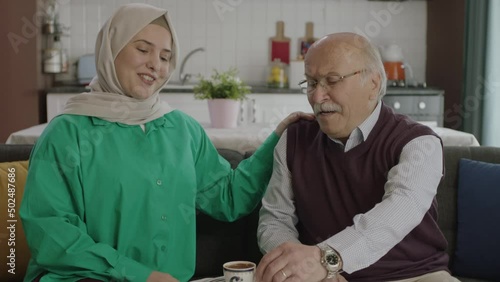 Happy loving old man drinking Turkish coffee in traditional cup.Old man having a good time chatting with his visiting daughter while drinking Turkish coffee.Happy father and daughter portrait.