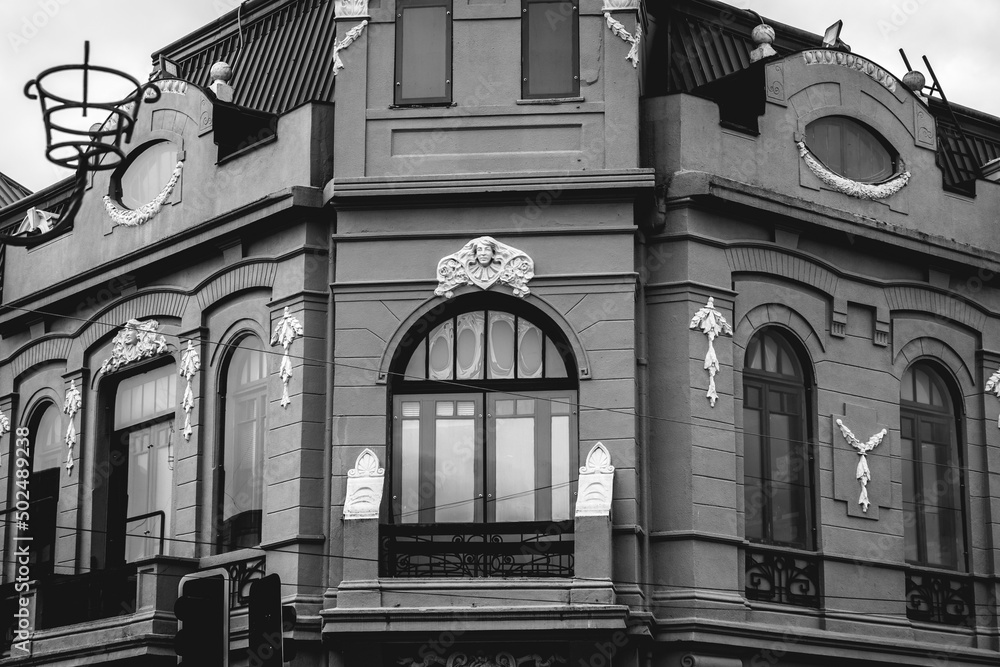 Beautiful windows and balconies in a old centuries building with neoclassical architecture, ornaments and sculptures in a cloudy day, Valdivia, Chile (in black and white) Beautiful windows and balconies in a old centuries building with neoclassical architecture, ornaments and sculptures in a cloudy day, Valdivia, Chile (in black and white)