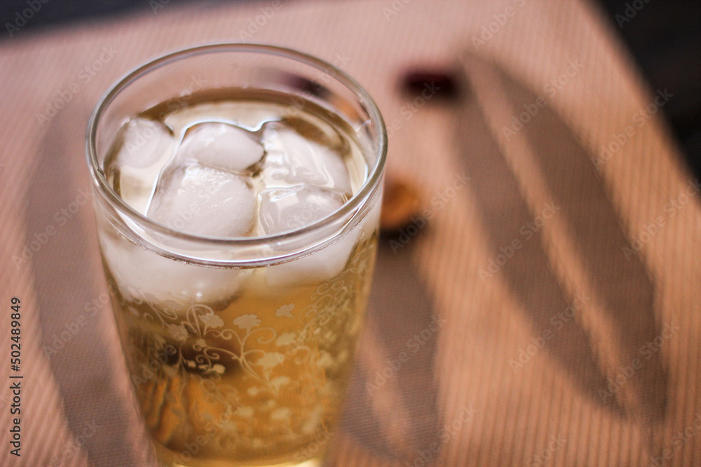 Chrysanthemum Juice, chilled, served in a clear glass placed on a black table Chrysanthemum Juice, chilled, served in a clear glass placed on a black table