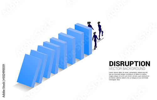 Silhouette of businessman and businesswoman walking from the end of domino collapse. Concept of business industry disrupt