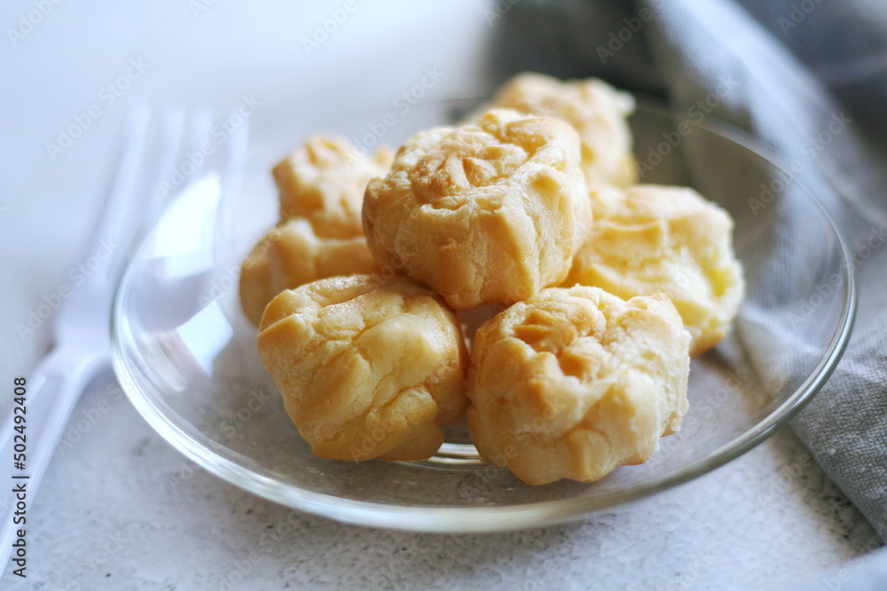 The eclair is placed in a glass dish on a white table. The eclair is placed in a glass dish on a white table.