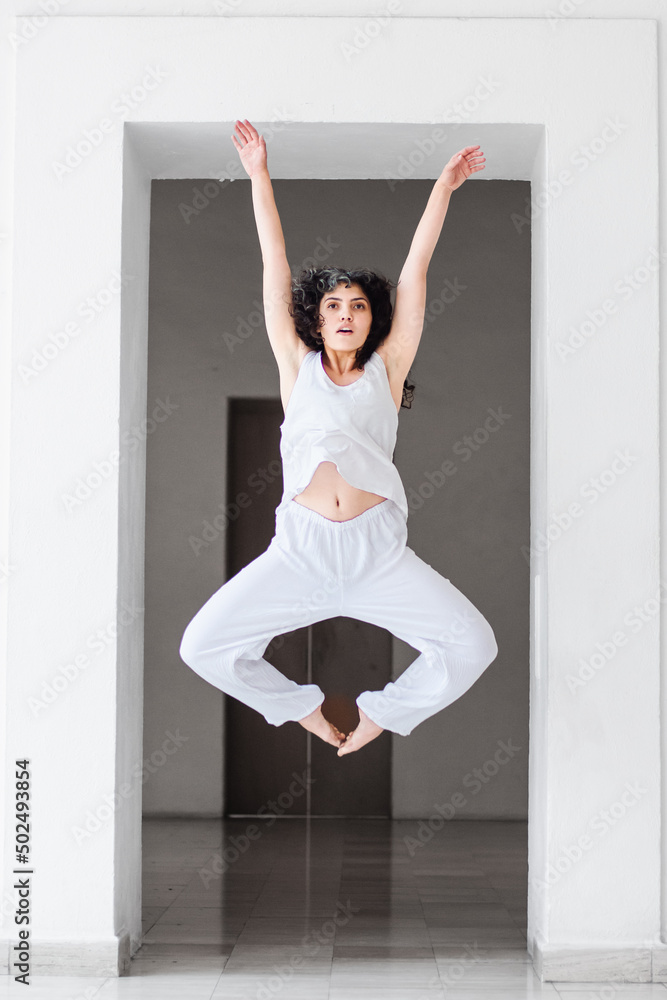Young woman performing a dance jump in a studio