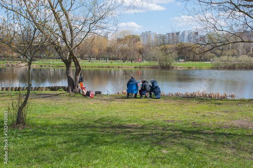 Three people are resting on the left bank of the city park on May 1, 2022 in Moscow
