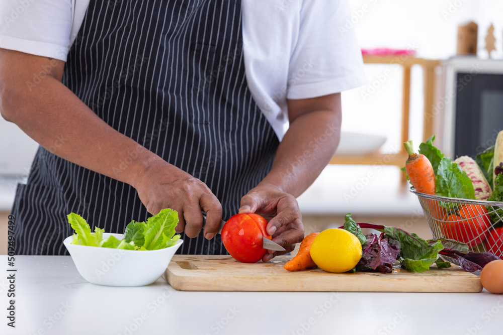 Senior men washes fresh corn by water in the kitchen for good health .There are fresh eggs on the table for preparing food.Senior life Senior men washes fresh corn by water in the kitchen for good health .There are fresh eggs on the table for preparing food.Senior life