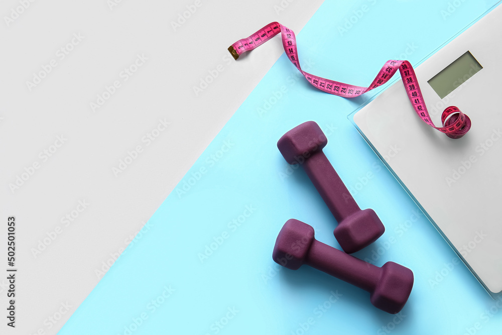 Dumbbells, measuring tape and scales on color background Dumbbells, measuring tape and scales on color background