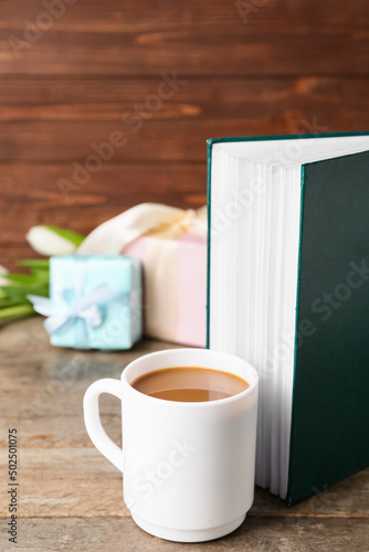 Cup of coffee and book on w...