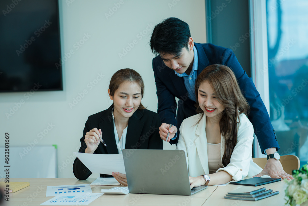 A group of young Asian businessmen working as a team brainstorm, analyze a financial chart, or discuss a marketing plan. Women leaders present and plan new business strategies. teamwork concept