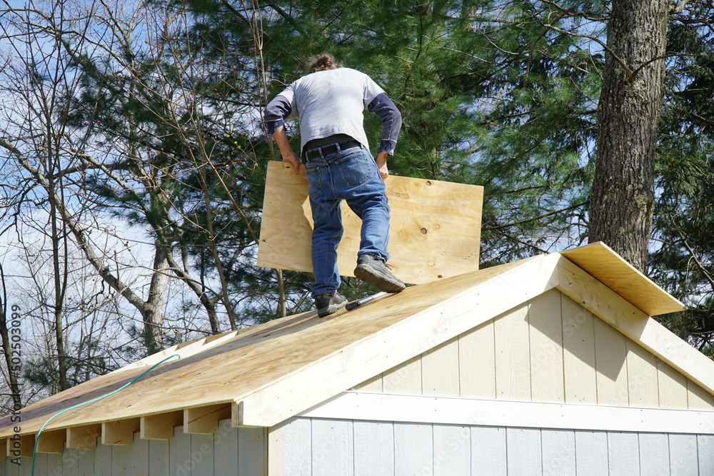 worker building the roof of the house