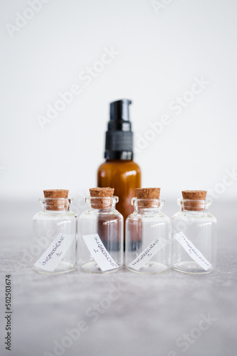 natural beauty and organic ingredients in skincare, amber skincare bottle with small bottles of ingredients next to it
