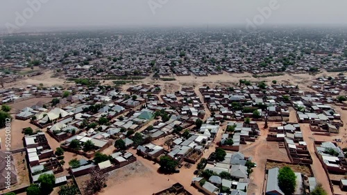 The sprawling city of Potiskum Town in the Yobe State of Nigeria with dirt roads and a dense population - ascending aerial view photo