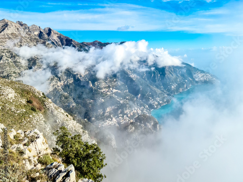 Fototapeta Naklejka Na Ścianę i Meble -  Panoramic view from Monte Comune on the coastal town Positano appearing from clouds. Magical hiking above thick fog in Lattari Mountains, Apennines, Amalfi Coast, Campania, Italy, Europe. Misty vibes