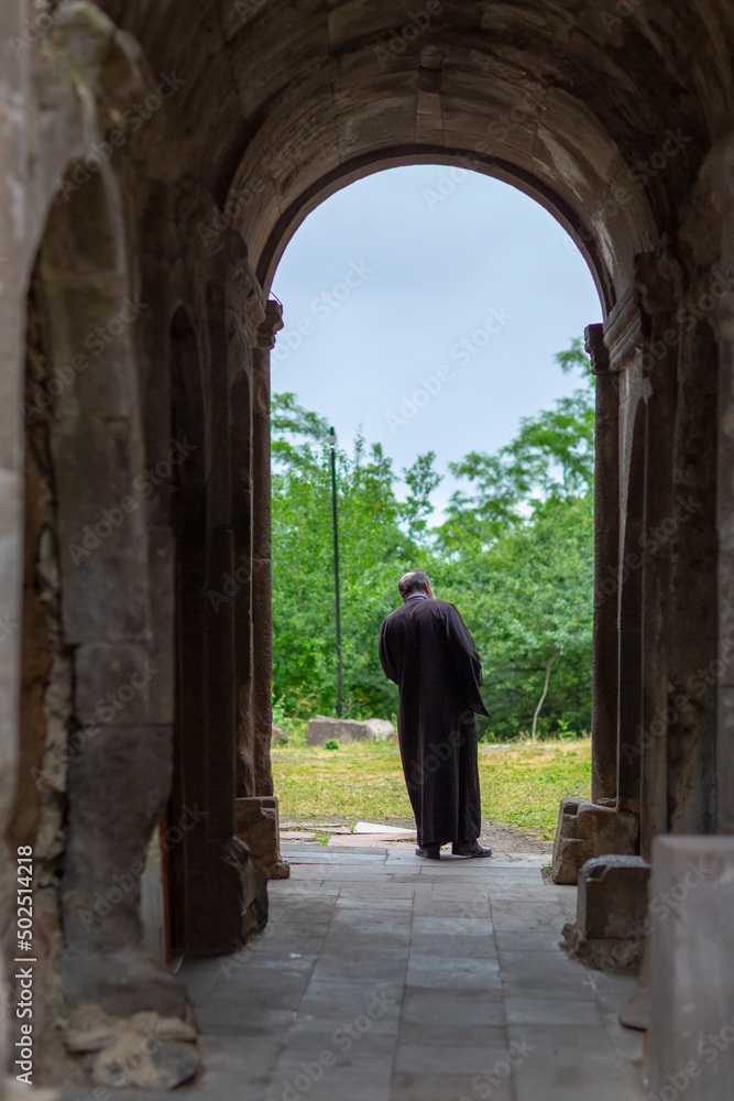 Priest walking through the arch