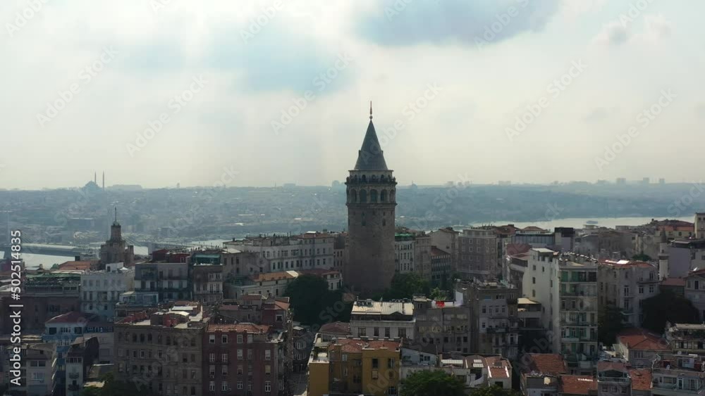 Aerial drone flying upwards revealing a silhouette of buildings surrounding Galata Tower in Taksim Istanbul Turkey Aerial drone flying upwards revealing a silhouette of buildings surrounding Galata Tower in Taksim Istanbul Turkey
