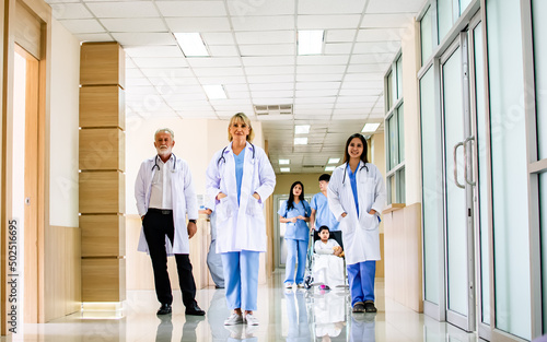 Doctors and patients standing, walking at clean comfortable hallway area and reception of modern clinic or hospital. Service, Health and Insurance Concept.