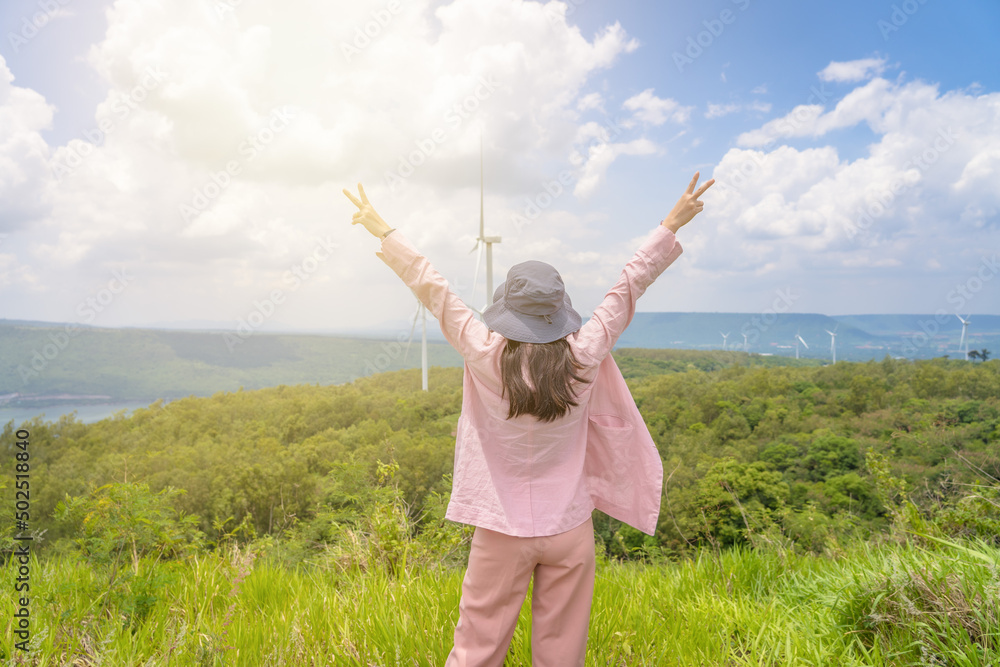 happy traveling girl enjoying a scenic road trip-with wind power generator windmill on background.tif happy traveling girl enjoying a scenic road trip-with wind power generator windmill on background.tif