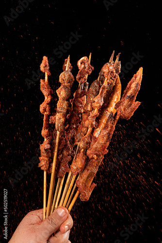 Shashlik. Kebab. Grilled barbecue meat with spices on black background