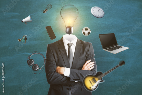 Abstract image of headless man with idea head, laptop, guitar and other items flying around on chalkboard wall background. Hobby and accupation concept. photo