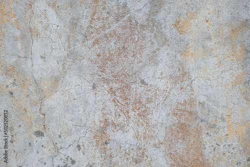 Old gray and white concrete wall with cracks and rust colored stains grunge background texture