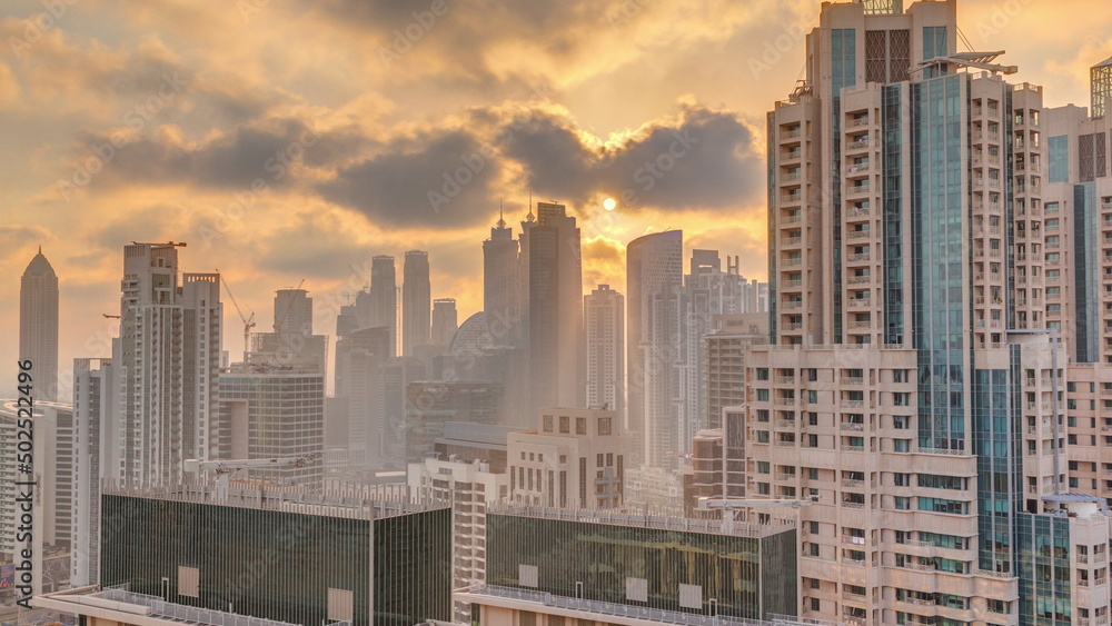 Dubai skyscrapers with golden sunset over business bay district timelapse. Dubai skyscrapers with golden sunset over business bay district timelapse.