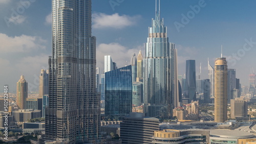 Skyscrapers rising above Dubai downtown timelapse  mall and fountain surrounded by modern buildings aerial top view