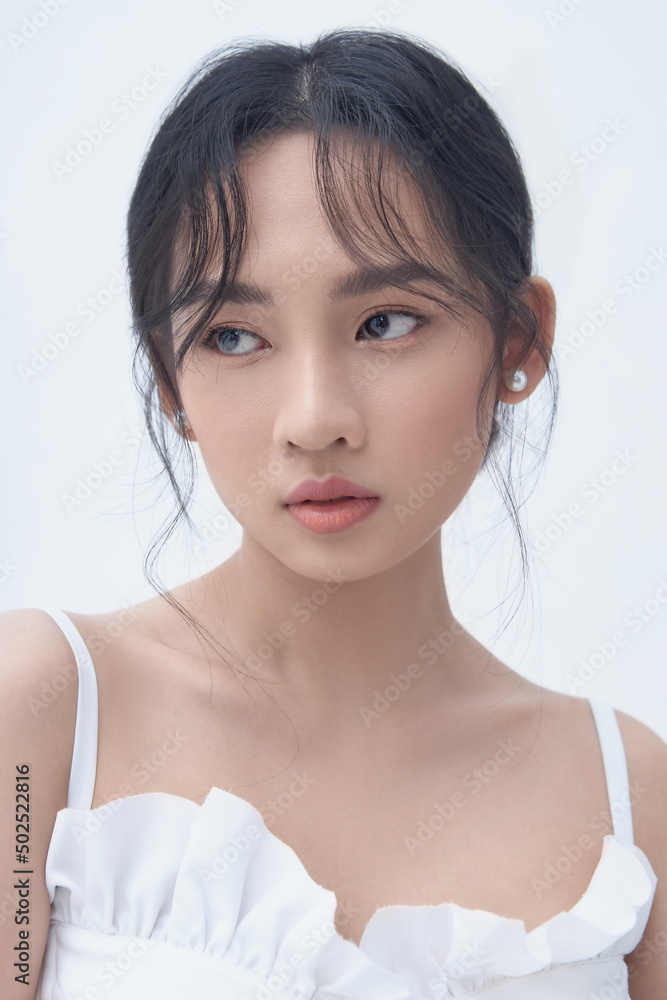 Beauty portrait of Asian female face with natural skin on white background Beauty portrait of Asian female face with natural skin on white background