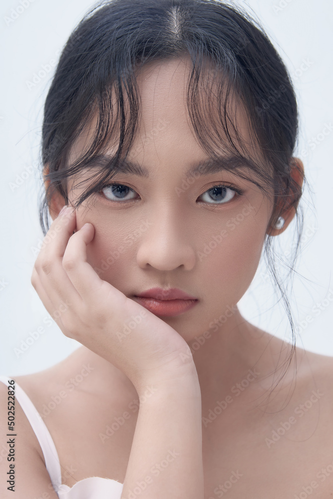 Beauty portrait of Asian female face with natural skin on white background Beauty portrait of Asian female face with natural skin on white background